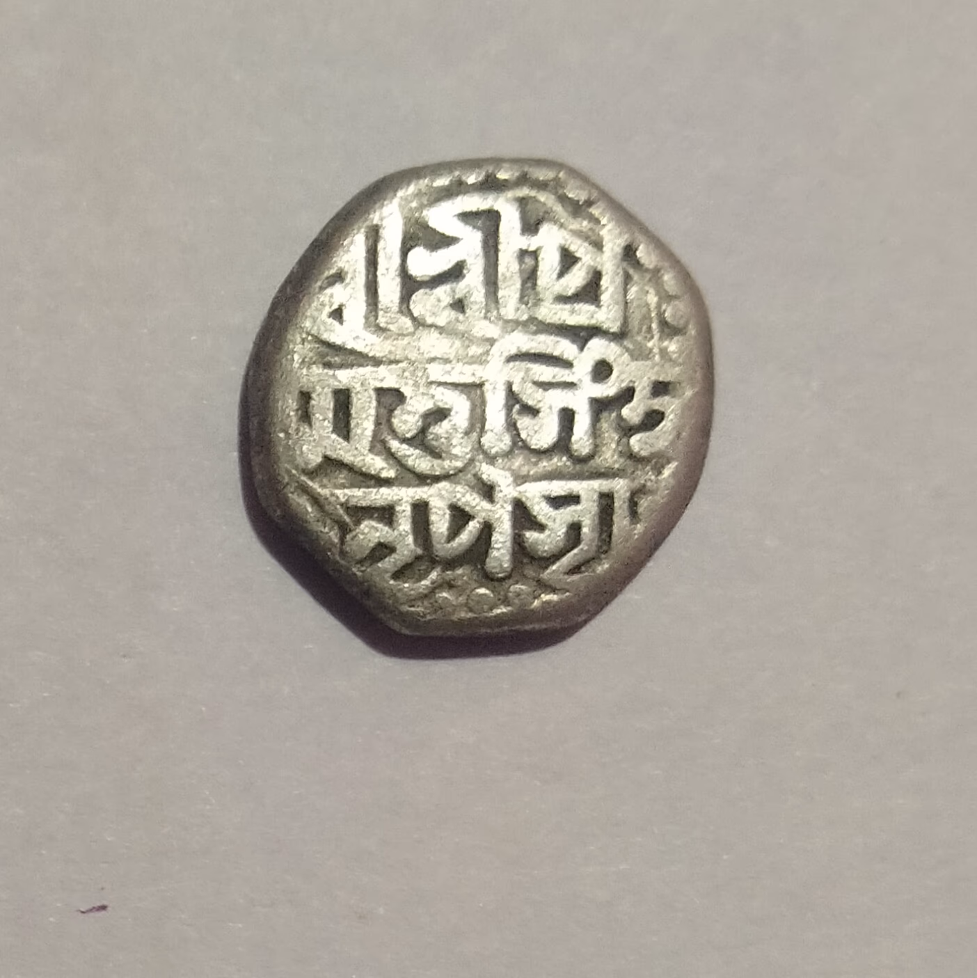 An octagonal Ahom silver rupee with multi-line legend in Assamese script recording the king's name and titles