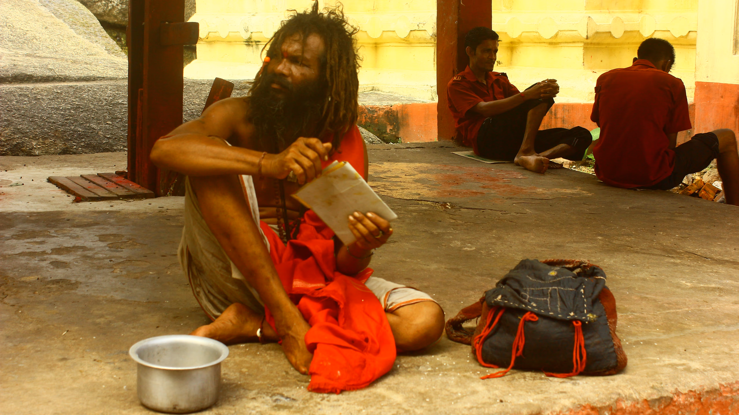 A tantric sadhu with long matted hair seated reading a manuscript on the grounds of the Kamakhya Temple